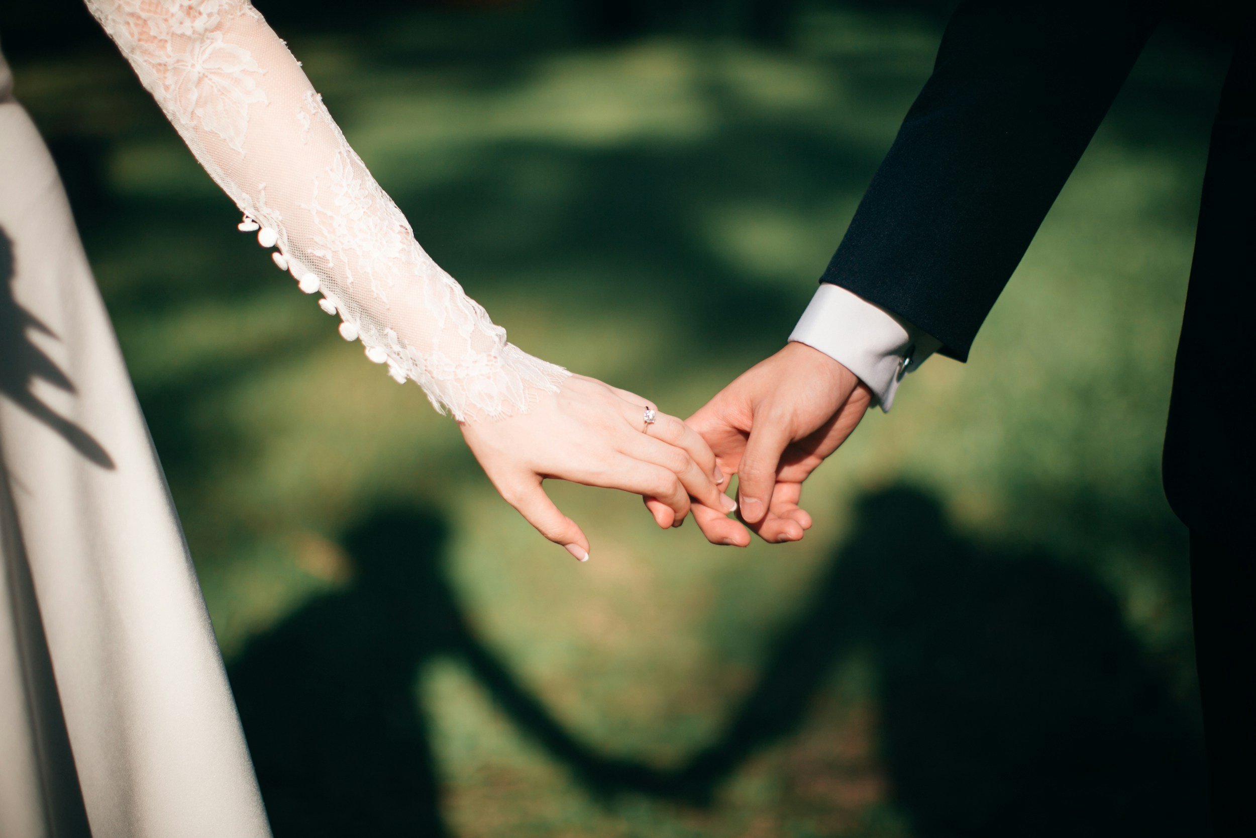 A couple holding hands on their wedding day.