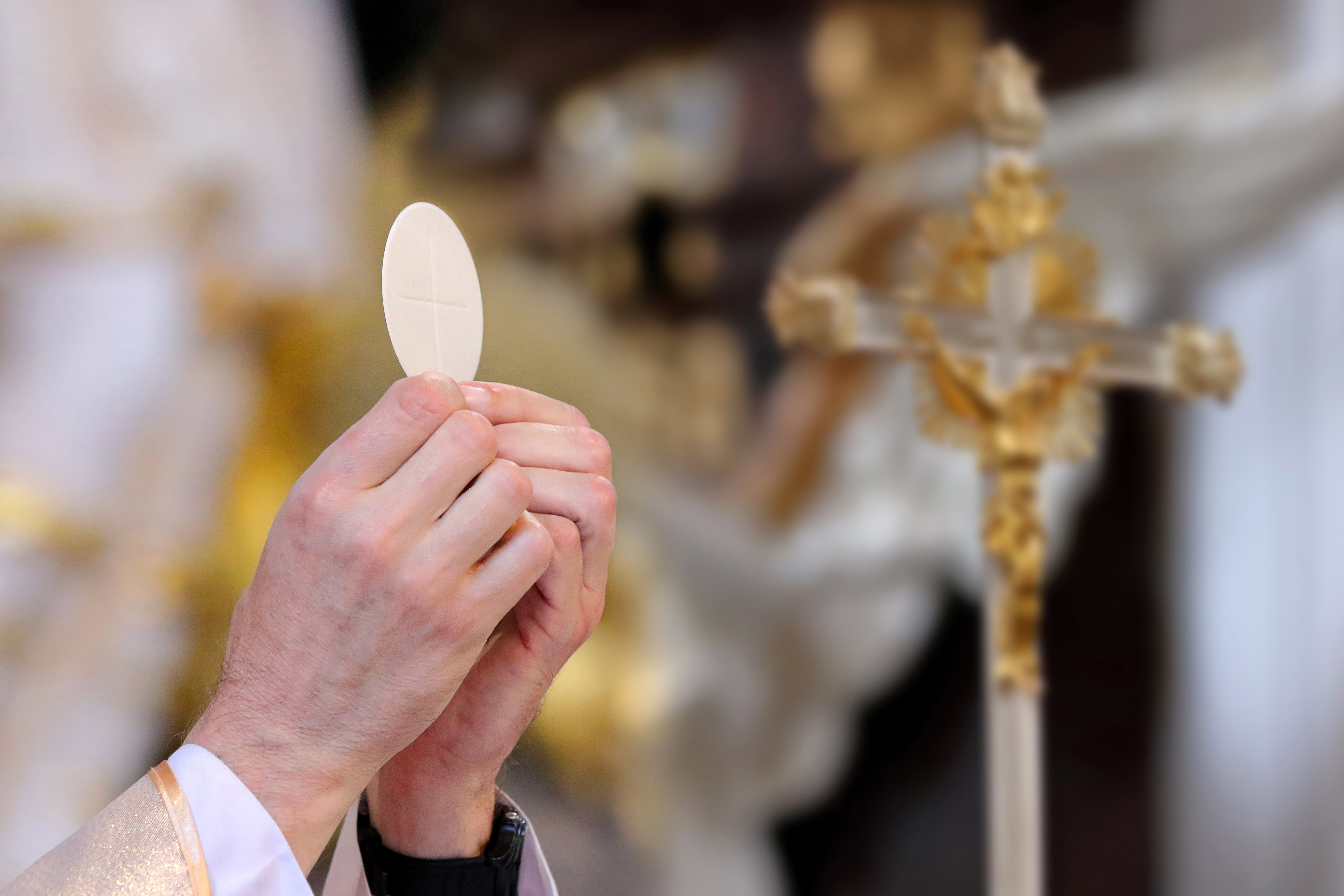 A Communion wafer held during the Eucharist.