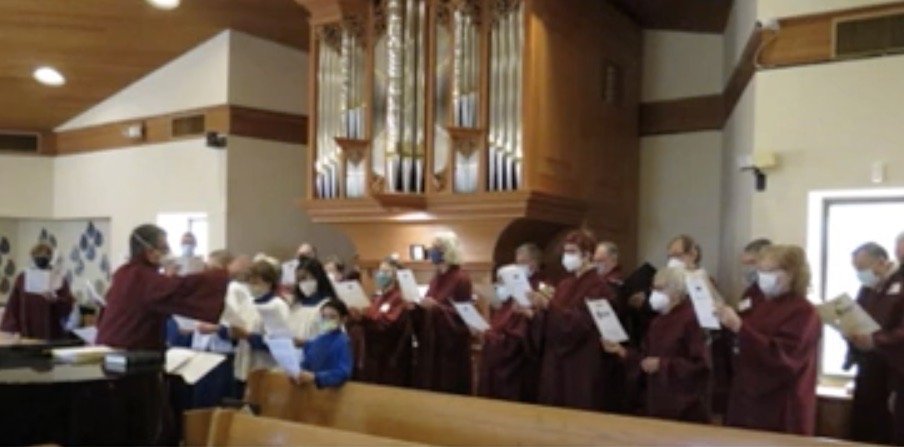 A choir gathered beneath the Fritts organ in St. Alban’s sanctuary.